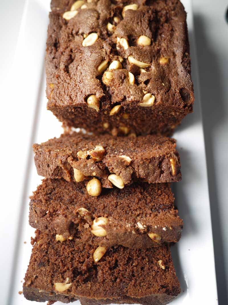 Salted Chocolate loaf cake with peanuts sliced on white plate