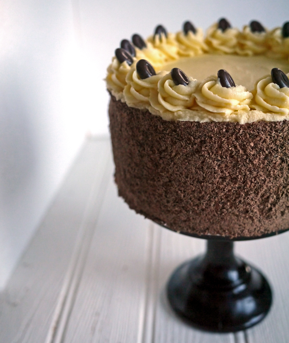 Side image of chocolate coffee sponge cake, decorated with chocolate curls and coffe flavoured buttercream