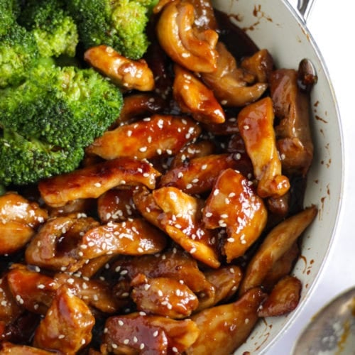 Chicken teriyaki sprinkled with sesame seeds and broccoli in the pan