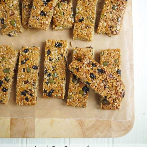 homemade granola lunch bar with fruits and seeds on a wooden chopping board