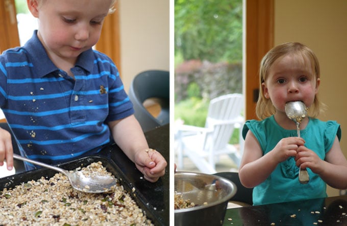 small boy pressing granola bar ingredients into black tin