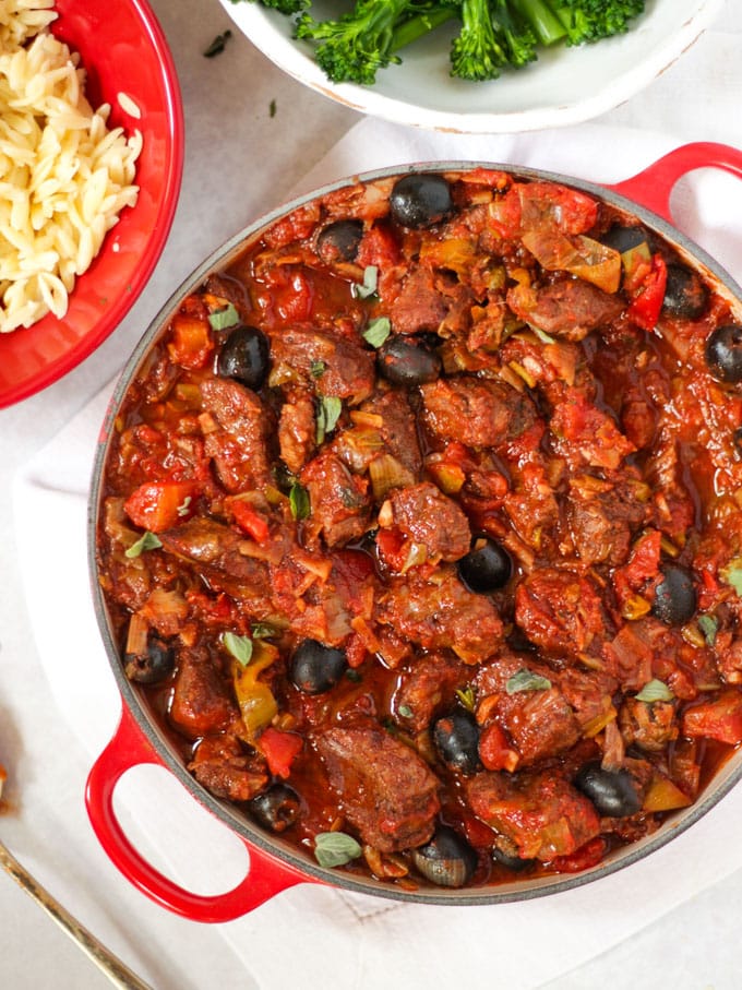 Tomato pork casserole, slimming world friendly, in a pan with olives and orzo pasta