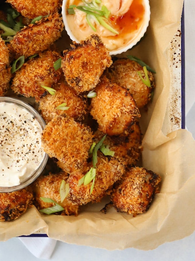 Homemade chicken nuggets coated in breadcrumbs with dipping sauces.