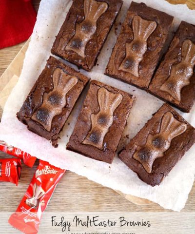 chocolate brownies topped with malteser bunnies on a white cloth with a wooden background