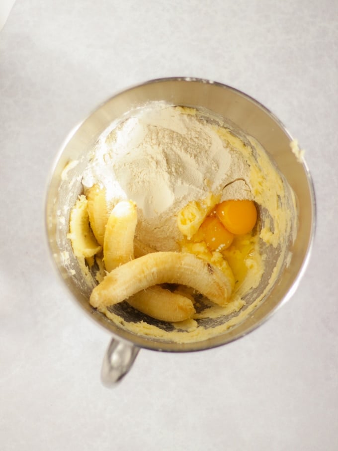 butter, sugar, bananas, eggs, and self raising flour in a kitchen aid mixing bowl for banana muffins