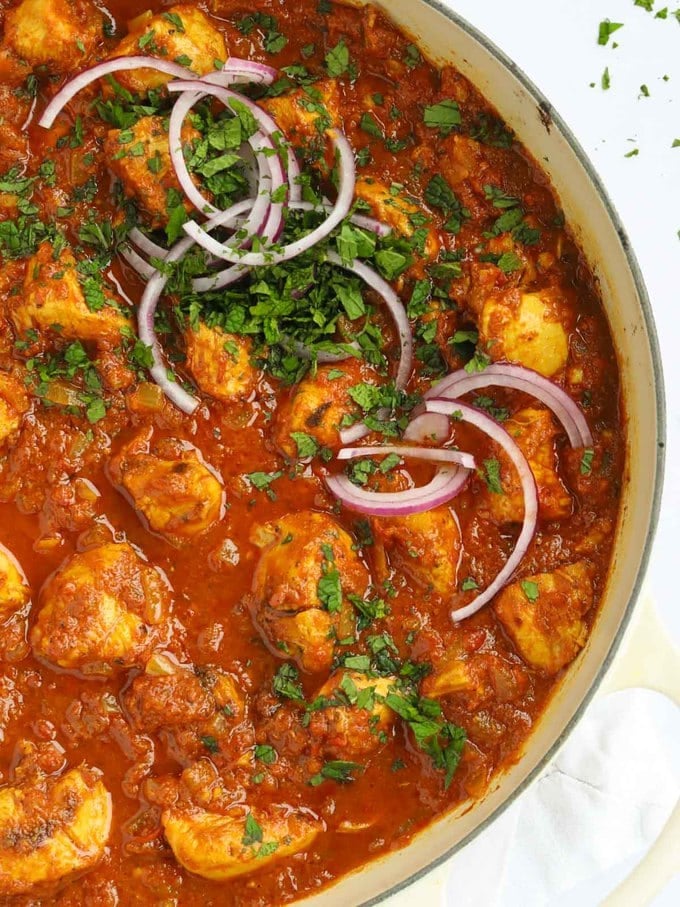 Batch cooking pot of easy chicken curry recipe. Topped with red onion and coriander.