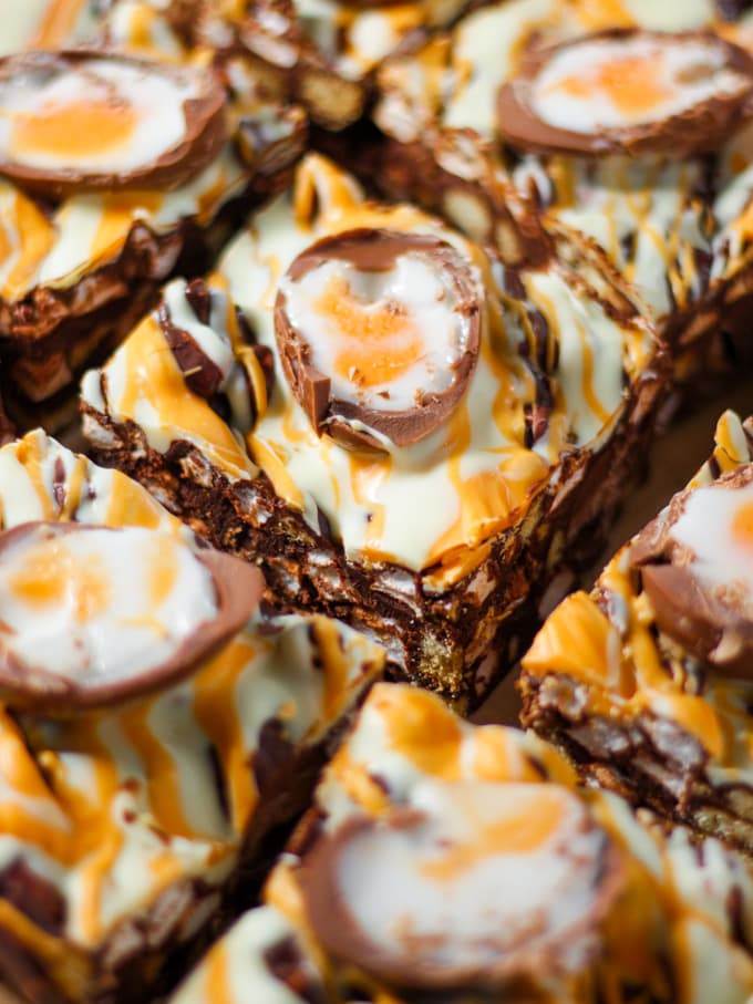 Squares of chocolate creme egg rocky road topped with creme eggs cut in half.