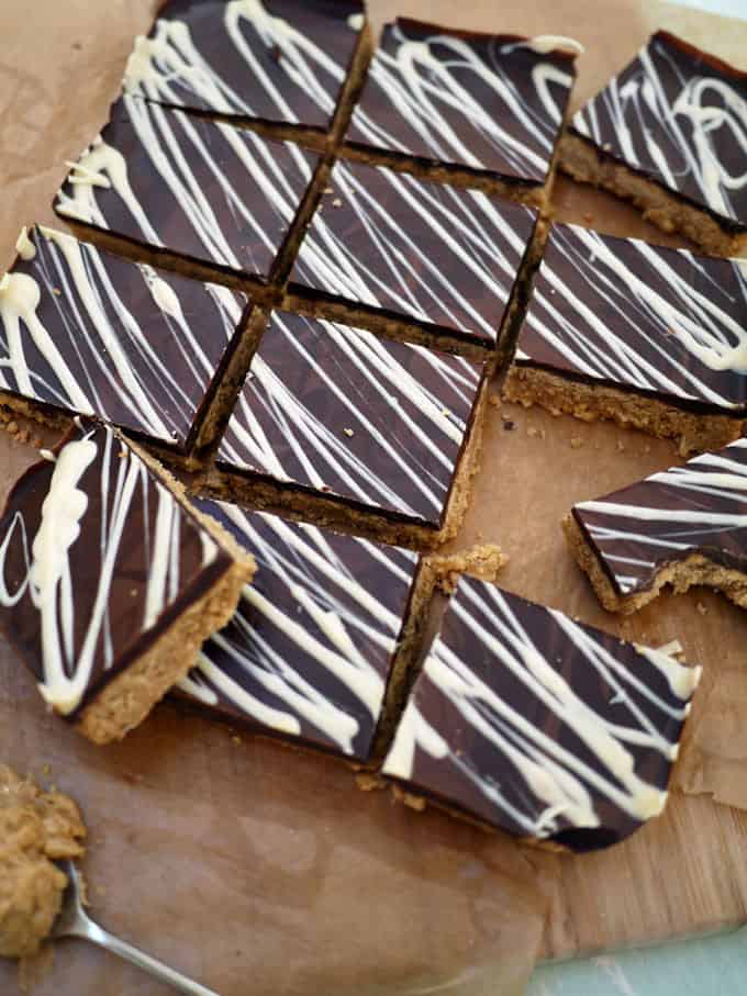 Peanut Butter Crunch Bars - Deliciously, moreish and easy to make tea time treats. Packed with peanut butter and topped with a slab of milk chocolate, these are a must bake! http://www.TamingTwins.com