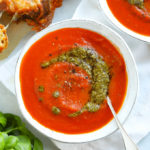 Easy tomato soup recipe with a swirl of pesto in a white bowl