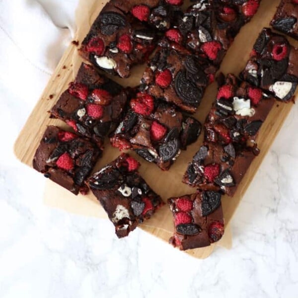 Fudgy, gooey, brownies, with a double layer of Oreos and raspberries. Because fresh fruit cancels out the chocolate, right?! A delicious birthday cake, piled high on a plate or a dessert, served with vanilla ice cream. https://www.tamingtwins.com