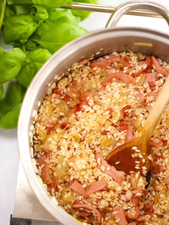 Rice with bacon and onions cooking in a saucepan