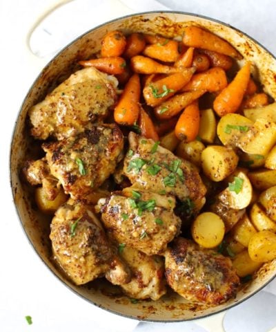 Honey and mustard chicken in a le creuset dish with carrots and potatoes