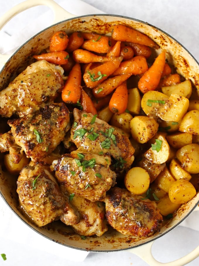 Chicken thighs with honey and mustard sauce with potatoes and carrots.
