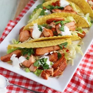 Easy, no cook salmon tacos. A perfect quick mid-week, assembly only dinner. Crispy taco shells, topped with salmon, lettuce, cheese, tomatoes, avocado and yoghurt.