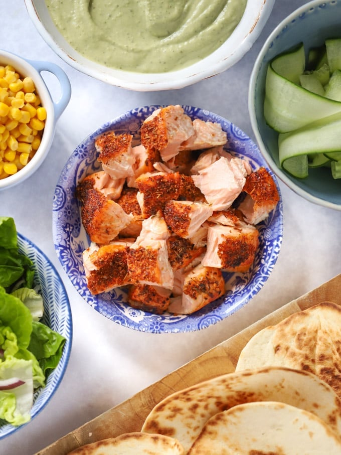 Cajun salmon pieces with cucumber, sweetcorn, lettuce and tortillas. 