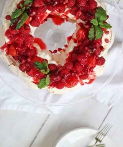 This Christmas wreath pavlova is the perfect meringue dessert for the festive season. A make ahead pudding, light and deliciously topped with cream, fruit and coulis, this is the ideal finish to the meal on the big day!