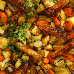 Simple sausage tray bake with carrots potatoes and leeks, all on one tray.