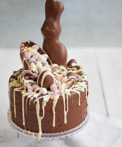 The Ultimate Easter Chocolate Cake! Overload on Easter treats in this decadent, delicious and rich Easter chocolate cake. Topped with Cadbury's Creme Eggs, Mini Eggs, white chocolate drizzle, bunnies and Caramel Eggs. What more could you need in an Easter dessert?!