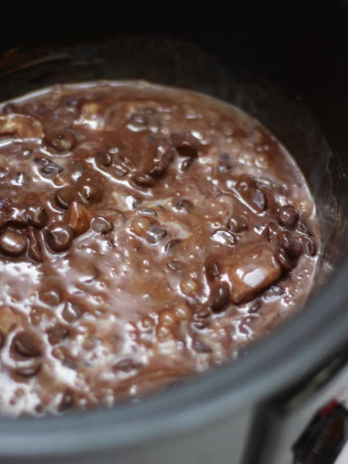 Slow cooker full of chocolate and condensed milk for slow cooker fudge.