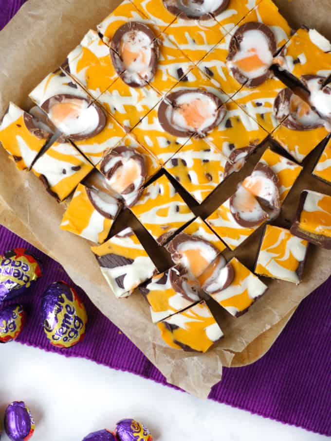 Overhead photo of yellow drizzled Creme Egg chocolate fudge cut into small squares.