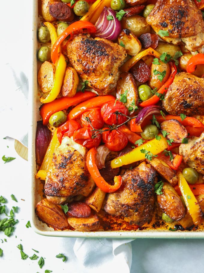 Baking sheet with chicken thighs, peppers and chorizo for the recipe Chicken and Chorizo Tray Bake.