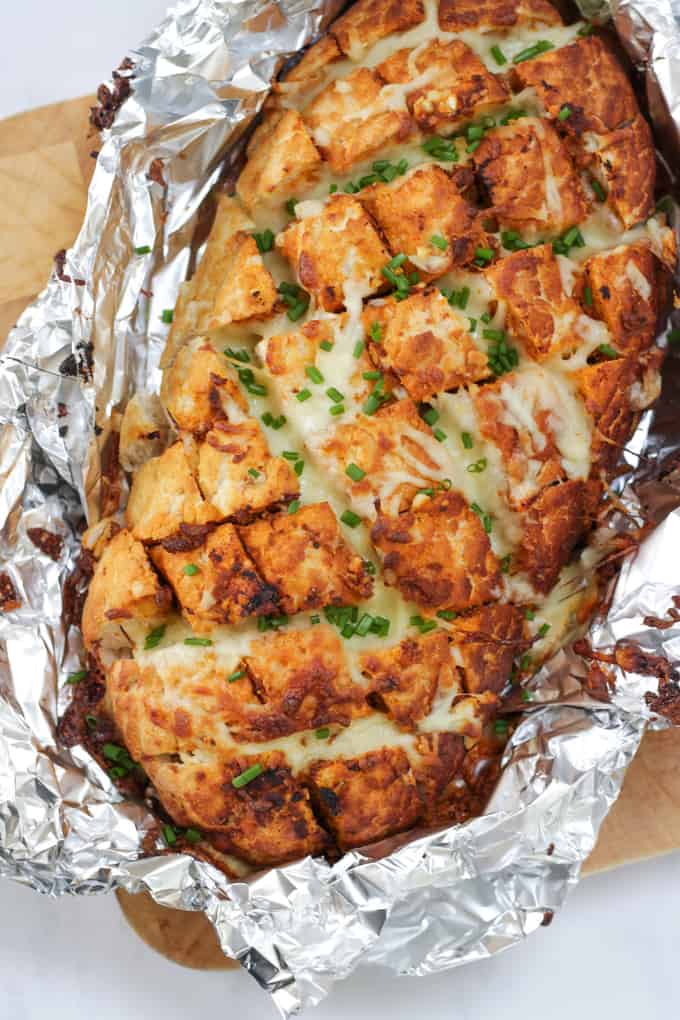 Cheesy Pesto Garlic Pull Apart Bread - A cheese filled treat. The perfect side dish for dinner or snacking. Pesto adds a depth of flavour to this pull apart bread with the mountains of melting mozzarella cheese.