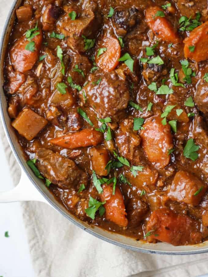 Overhead close up of beef Guinness stew recipe with carrots and sprinkled with parsley.