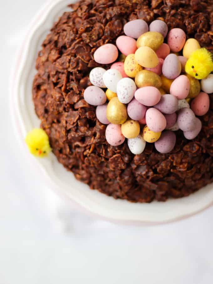 Overhead view of a giant Easter next cornflake cake with mini egg chocolates in the centre.