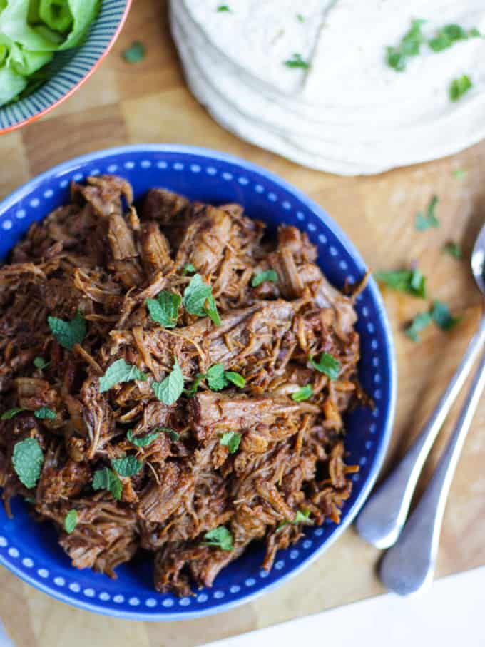 Overhead shot of instant pot pulled pork recipe sprinkled with mint.