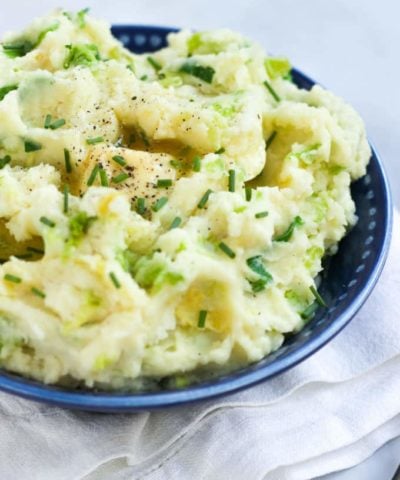 Colcannon mashed potatoes sprinkled with chives and piece of butter melting.