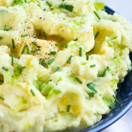 Colcannon mashed potatoes sprinkled with chives and piece of butter melting.