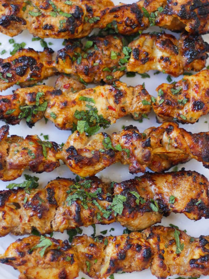 Overhead photo of chicken kebabs on bamboo skewers.