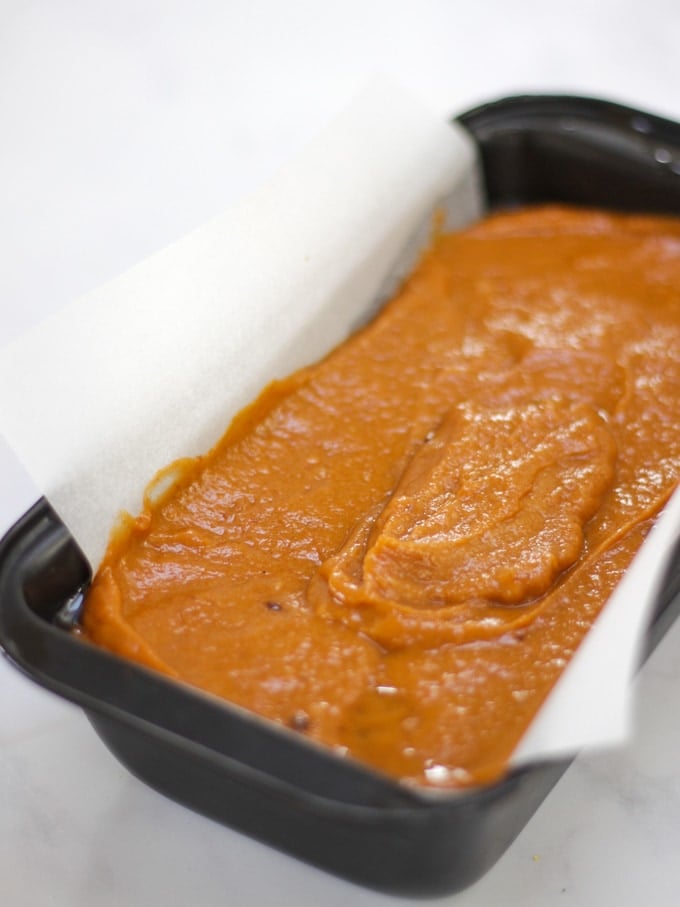 Photo of uncooked pumpkin spice loaf in a loaf tin for pumpkin cake recipe.