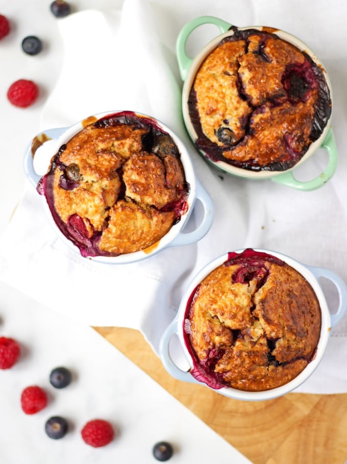 Overhead photo of baked oats in small ramekins on a white background.