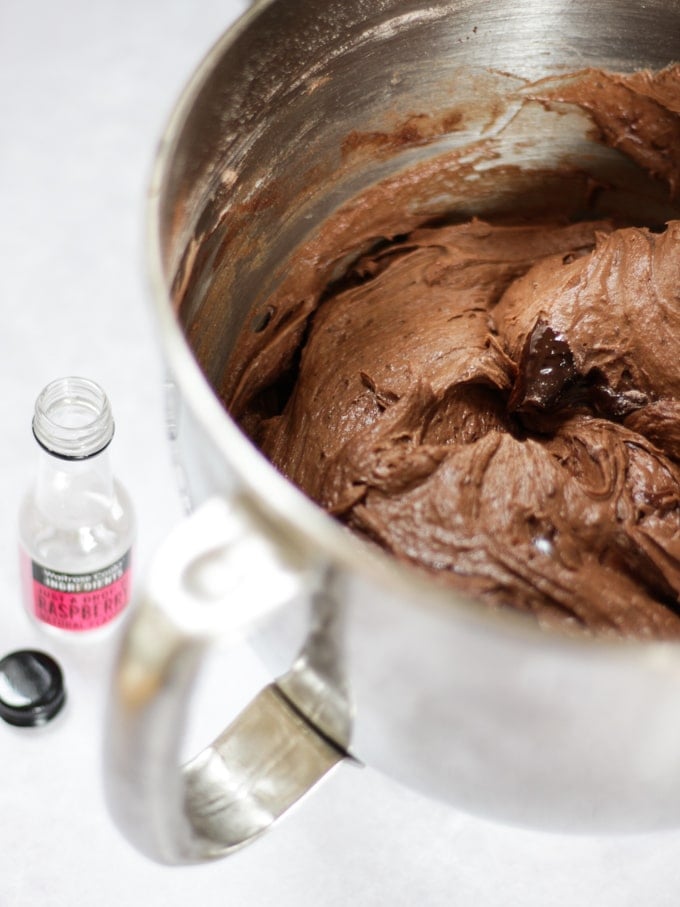 Black kitchen aid mixer inside the bowl full of chocolate cake batter for raspberry cake.
