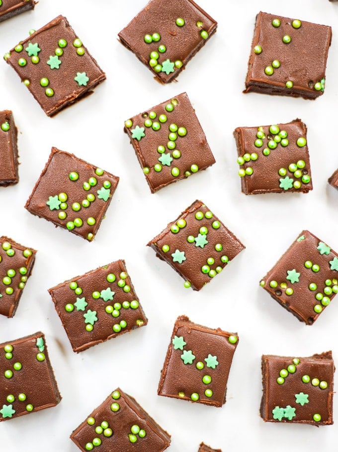 Overhead photo of baileys fudge made with easy microwave recipe on white marble background with green sprinkles.