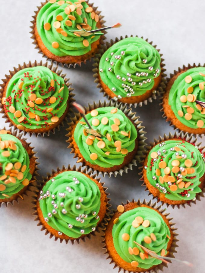 Overhead photo of green iced Christmas tree cupcakes with sprinkles.