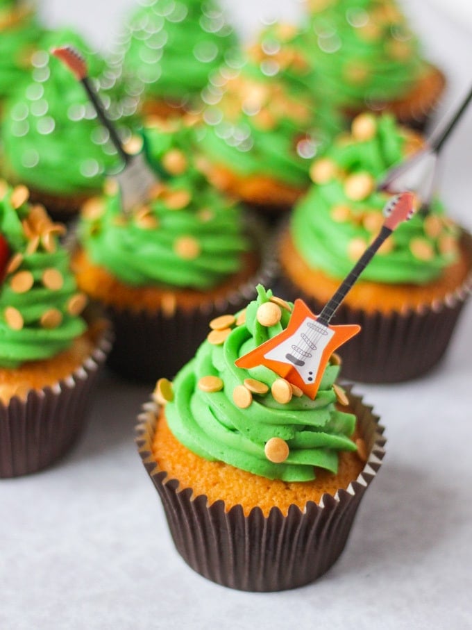 Side photo of green iced Christmas tree cupcakes with sprinkles.