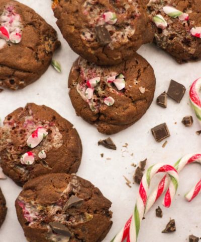 Candy cane cookies on white marble background with chocolate.
