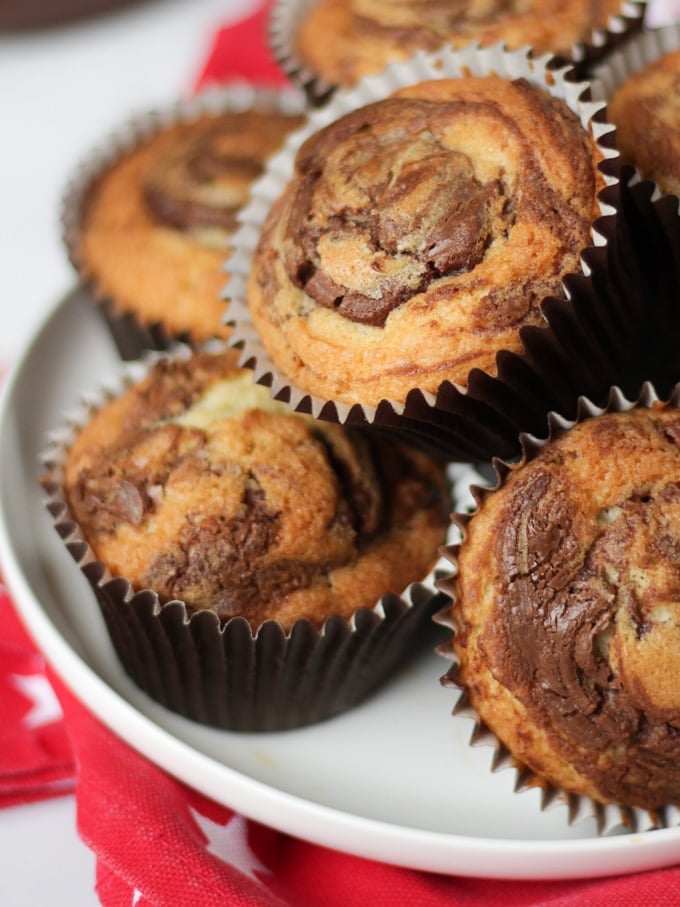 Pile of cupcakes with chocolate swirl on a plate.