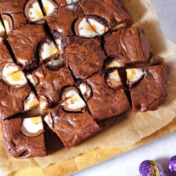 Creme Egg Brownies cut into squares topped with chocolate creme eggs cut in half