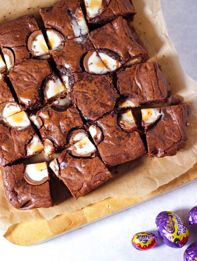 Creme Egg Brownies cut into squares topped with chocolate creme eggs cut in half