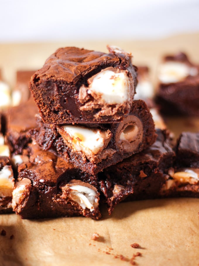 Pile of three creme egg brownies piled up with creme eggs cut through.