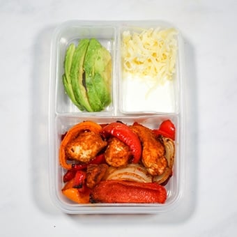 Leftover chicken fajitas in a plastic compartment lunchbox as a healthy lunch