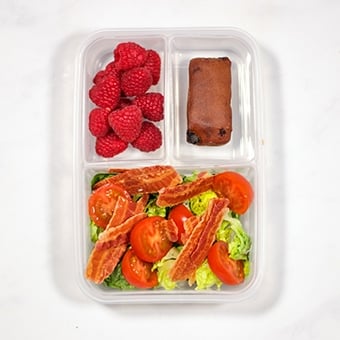 Lunchbox with BLT salad, raspberries and malt load