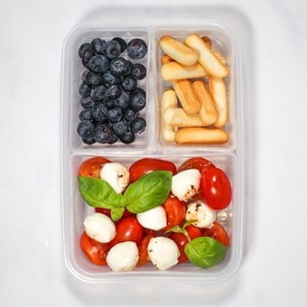 Plastic lunchbox with tomato mozzarella salad, healthy lunch idea for work