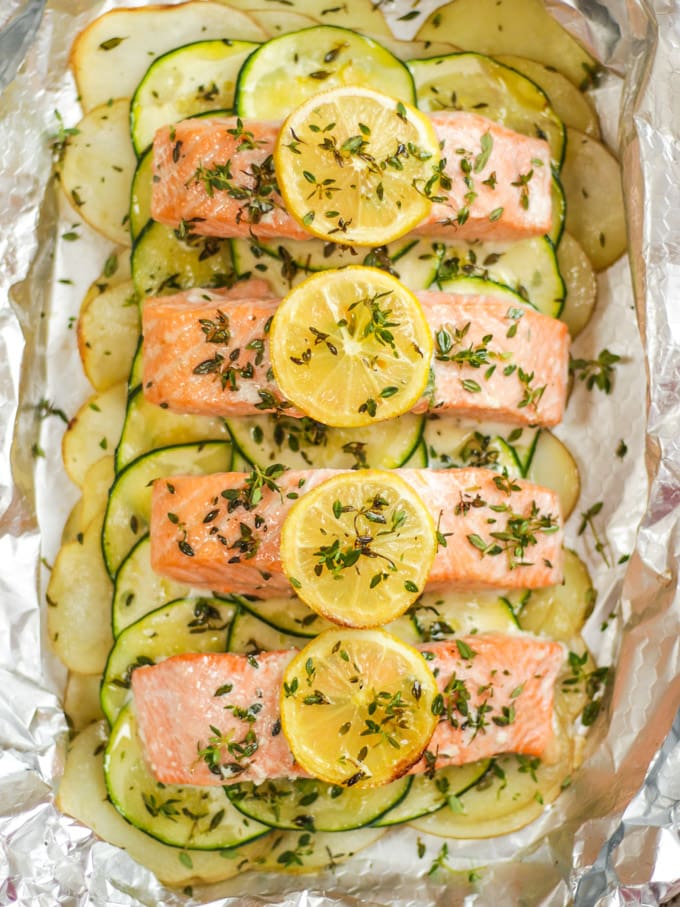 Four salmon fillets in foil baked in the oven.