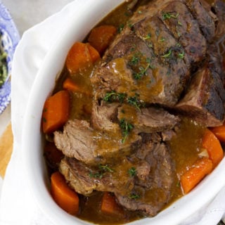 Sliced slow cooked joint of beef with carrots and onions
