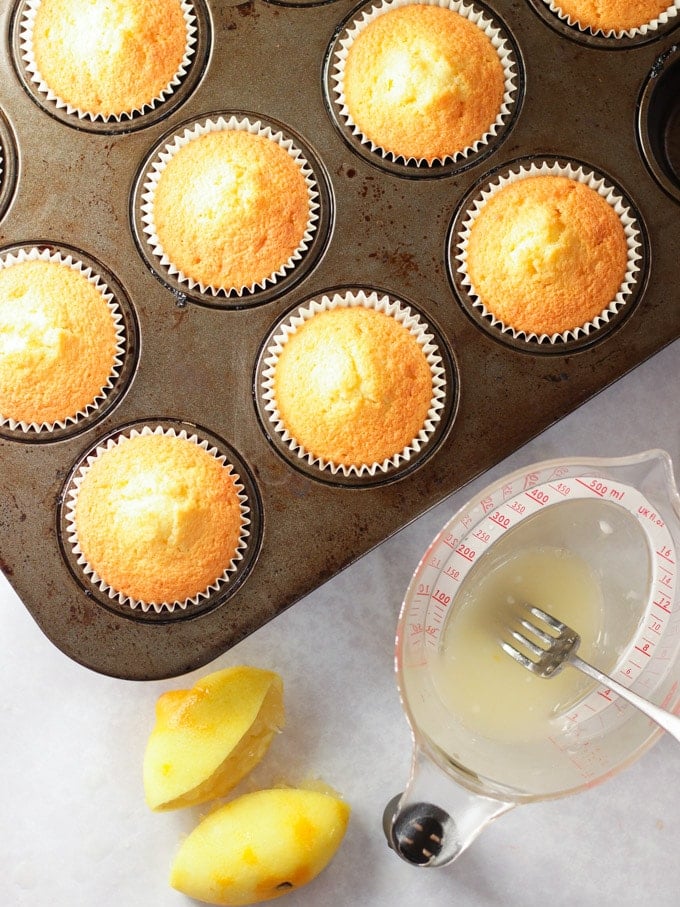 Baked cupcakes ready to have lemon drizzle topping poured over them