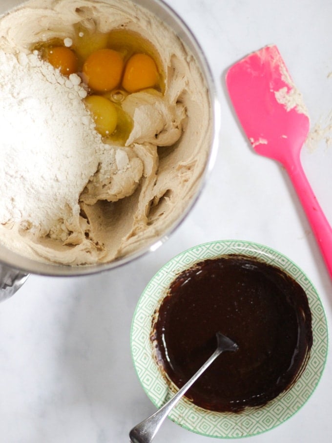 Batter ingredients in a bowl, pink spatula and cocoa mix ready to be added